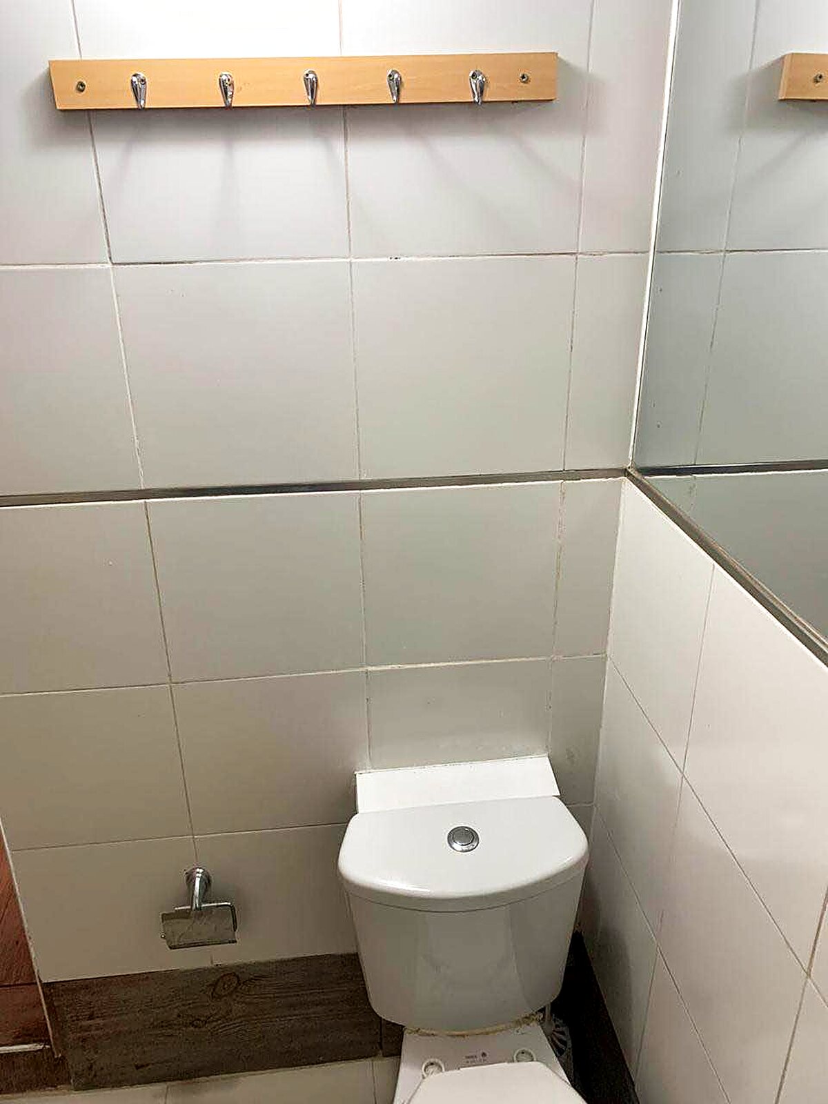 Baño enchapado en cerámico con percheros