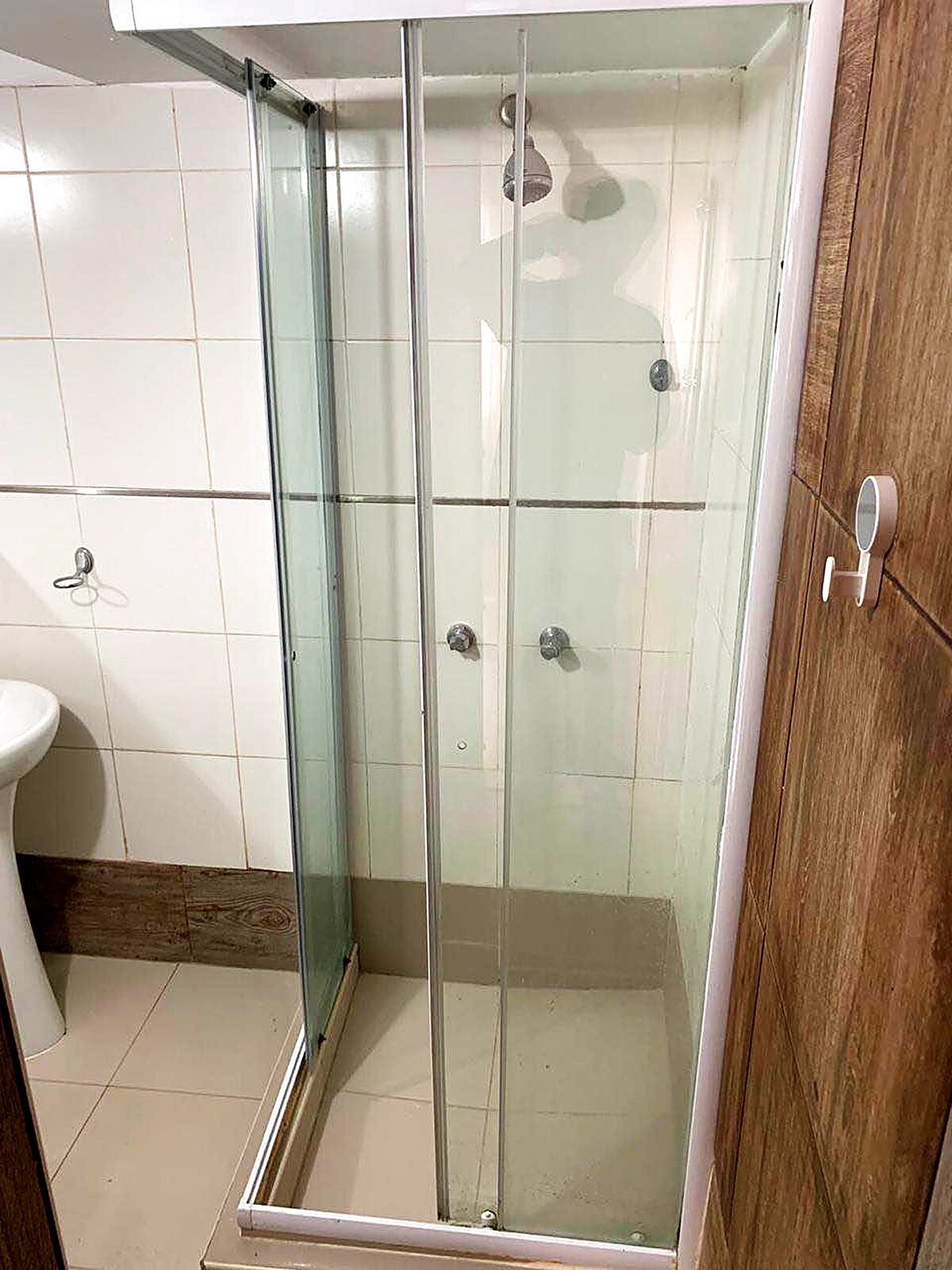 Ducha con mampara de vidrio dentro del baño propio